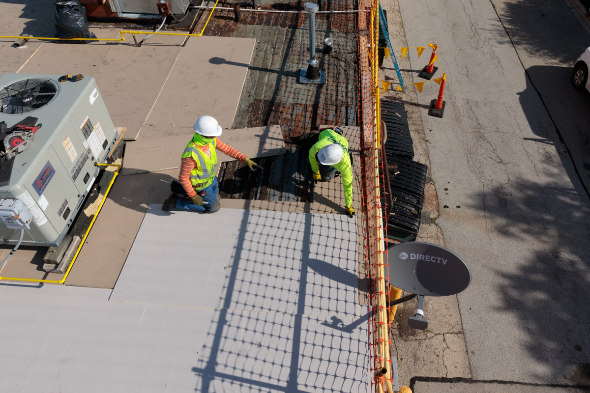 Roofers reroofing a commercial building