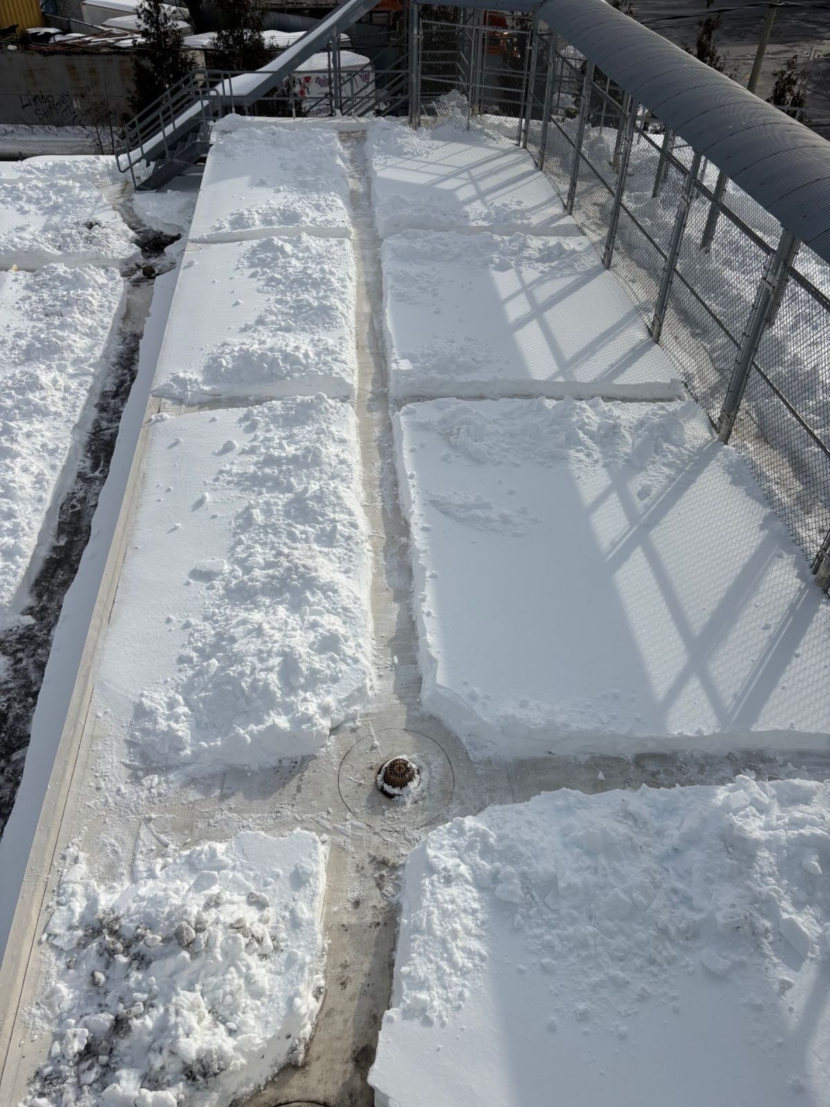 Crew clearing a rooftop walkway with non-damaging tools