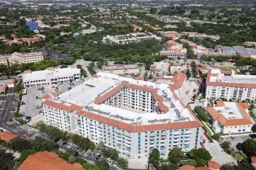 Aerial view: Modern Miami complex with central courtyard, green roofs, and TPO roofing.