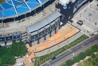 Aerial view of stadium blue roof and construction site, Charlotte roads visible.