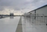 Houston commercial flat rooftop with metallic HVAC units under cloudy sky