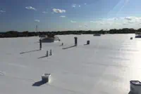 Houston commercial flat roof with vents and pipes under clear sky