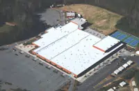 Aerial view of white-roofed commercial building in Atlanta, GA with parking lot