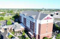 Aerial view: Multi-story Hilton Garden Inn, Chicago, IL with gray flat roof surrounded by greenery.