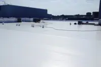 Wide-angle view: Commercial roof installation with workers, equipment in San Diego, CA.