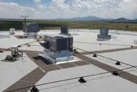 Houston commercial rooftop with HVAC units, ventilation systems under cloudy sky