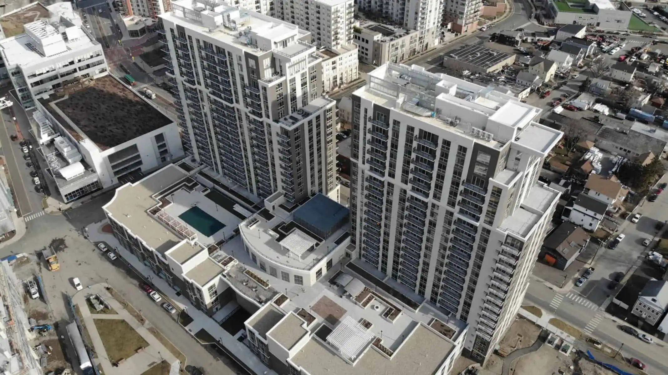 Aerial of urban high-rises with completed rooftop pool by Nations Roof