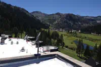 Rooftop View Over Valley: Lush Green Landscape, Denver Skyline, Forested Mountains