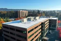 Aerial view: Multi-story office with white flat roof in autumn, Minneapolis, MN