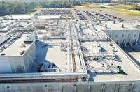 Aerial view of Dallas industrial facility with commercial flat roofs and extensive piping.