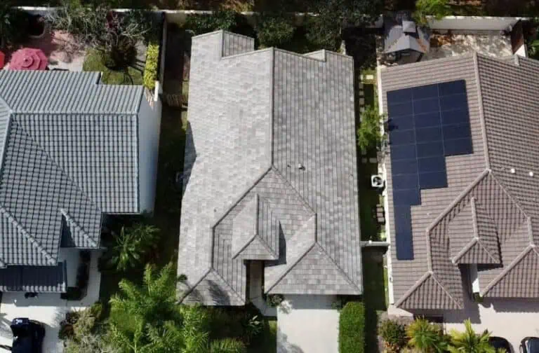 Aerial view: three diverse roof styles; gray, dark gray, brown with solar panels.