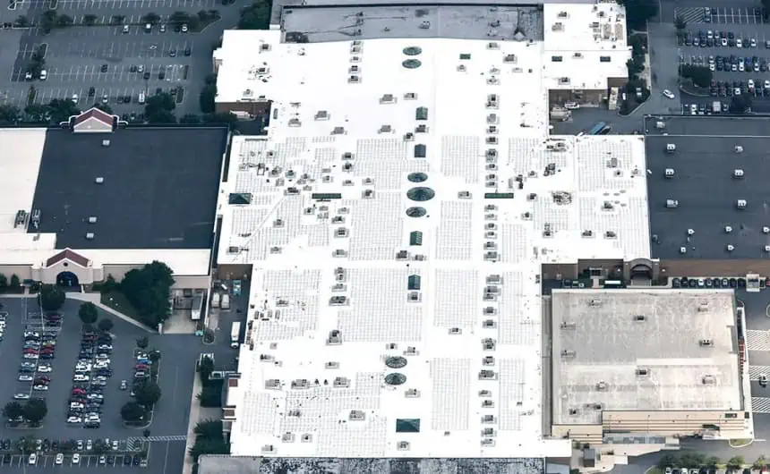 Aerial view of commercial building with white TPO rooftop and HVAC units