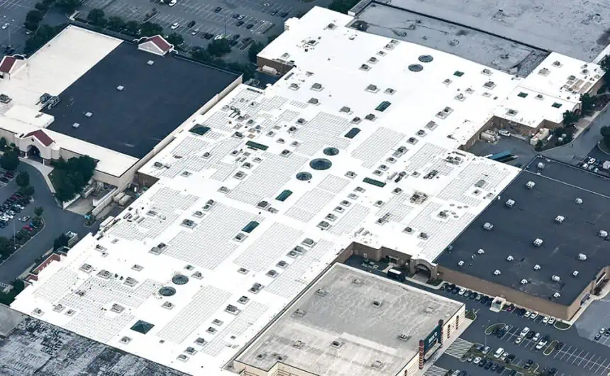 Aerial view of a commercial complex with white TPO rooftops and HVAC units