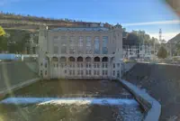 Concrete dam with arched openings in Phoenix, AZ; water flow below. Clear sky backdrop.