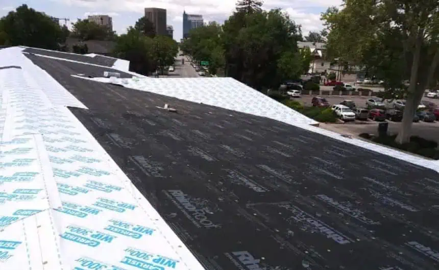 Commercial roof under construction with roofing felt and underlayment near Ronald McDonald House.