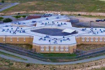 Aerial view of hexagonal correctional facility with advanced commercial roofing in Santa Fe County