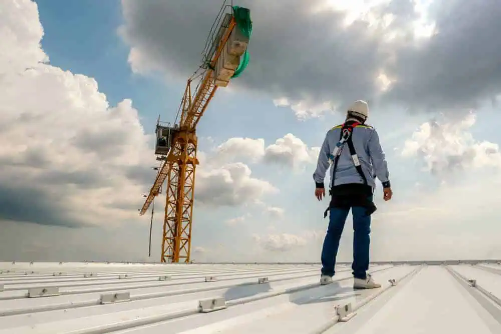 Commercial roofer stands on storm-resistant commercial roofing systems