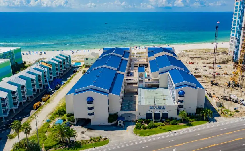 Aerial view of coastal resort with blue and green roofs near Sugar Beach.