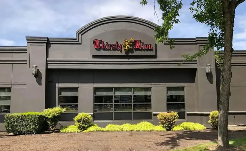 Thirsty Lion Gastropub with dark grey exterior and large windows, commercial flat roof installation.