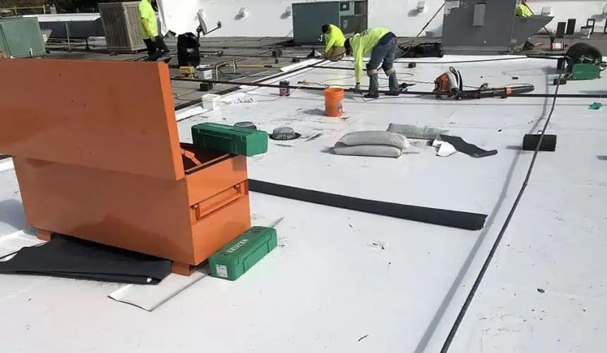 Commercial roof work with tools in Portland skyline backdrop