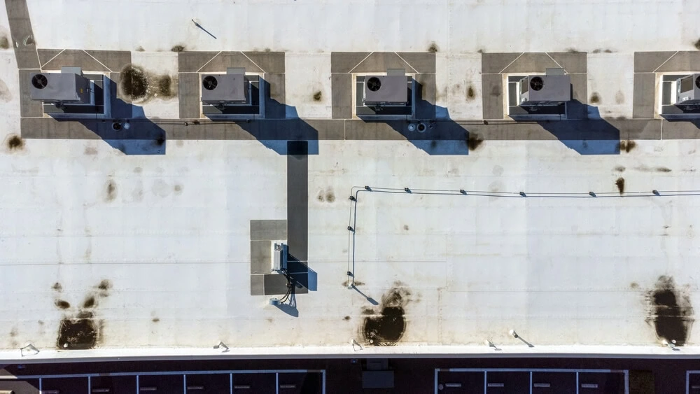 White commercial roof showing signs of discoloration and damage