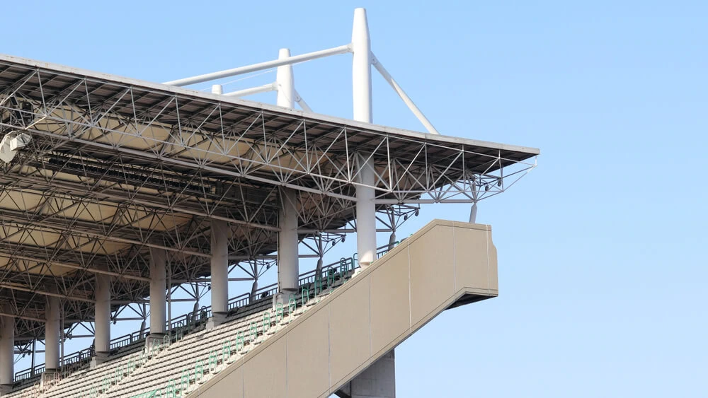 Metal stadium roof over upper deck bleachers.